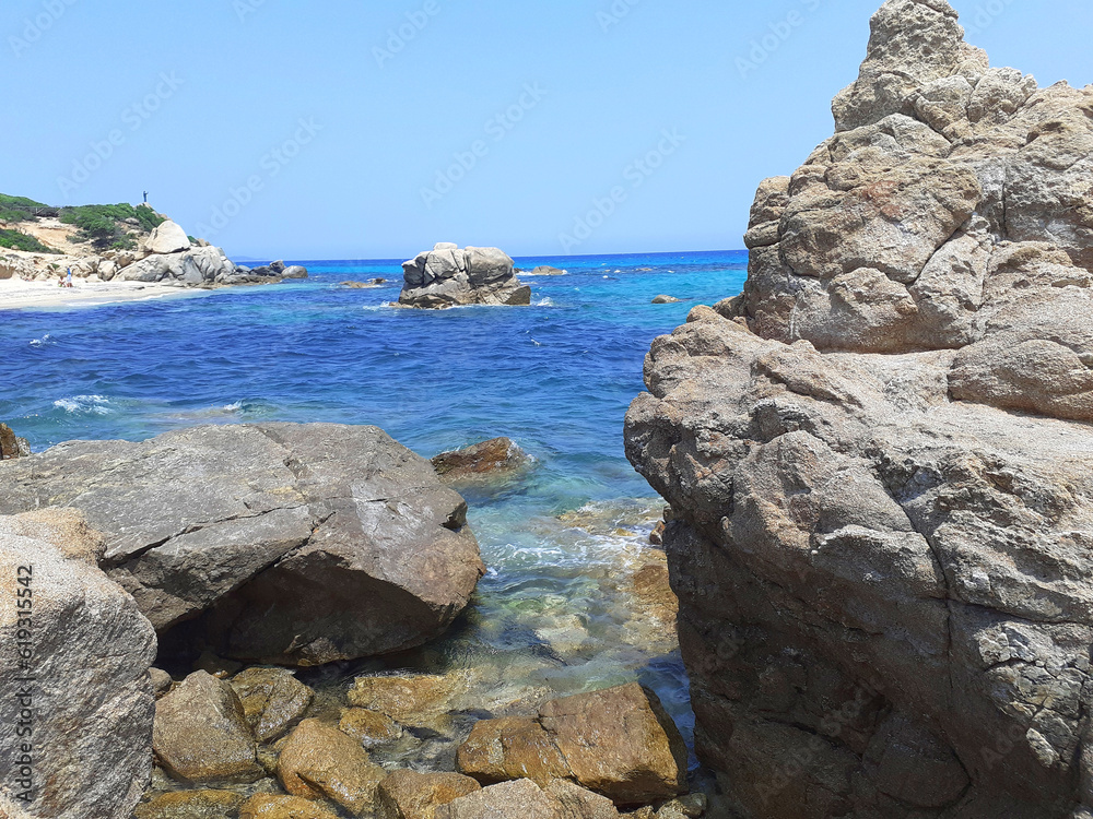 Castiadas, Italy - june 30, 2023: Punta di Santa Giusta beach, Costa Rei, in the province of the South Sardinia. A lot of soft sand between the rocks, an intense blue sea with very few bathers