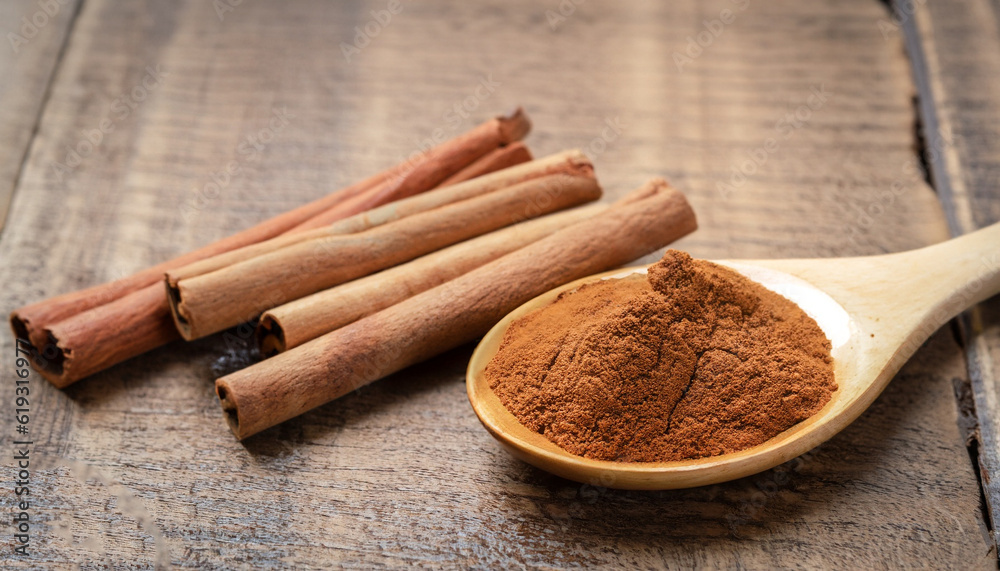 Close up cinnamon sticks and cinnamon powder in wooden spoon on wooden table background, healthy spice concept Close up cinnamon sticks and cinnamon powder in wooden spoon on wooden table background, healthy spice concept