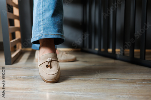Close-up of female legs in jeans and beige loafers made of genuine leather. photo