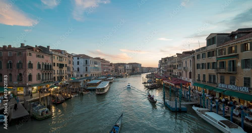 Day to night sunset timelapse of Grand canal from the Rialto Bridge in Venice, Italy, Europe. Time-lapse evening illumination Venetian city lights and famous romantic gondolas. Travel Destination. Day to night sunset timelapse of Grand canal from the Rialto Bridge in Venice, Italy, Europe. Time-lapse evening illumination Venetian city lights and famous romantic gondolas. Travel Destination.
