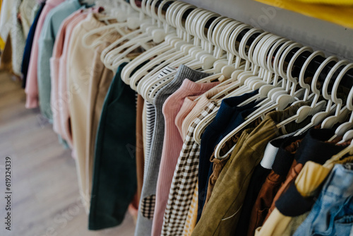 Children's clothing store. Lots of nice clothes for kids. Trousers, jeans, leggings and sweatpants on hangers in the store. Sale of clothes. Clothes for small children. Pants are hung on hangers.