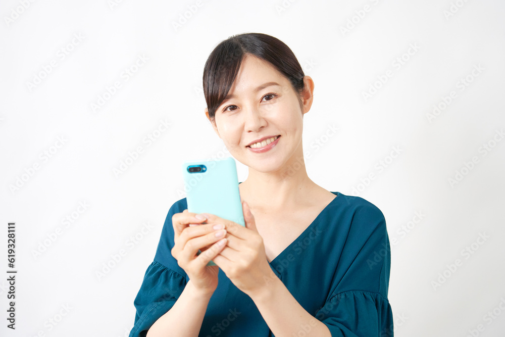 スマートフォンを使うミドルエイジ女性 白背景 カメラ目線 スマートフォンを使うミドルエイジ女性 白背景 カメラ目線