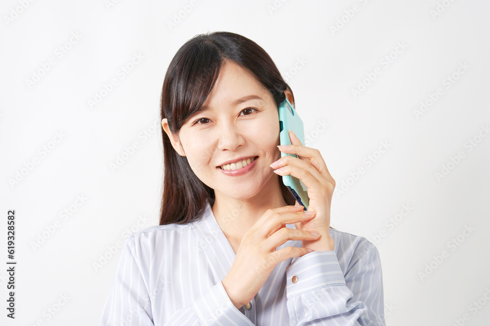 スマートフォンで電話するミドルエイジ女性 白背景 スマートフォンで電話するミドルエイジ女性 白背景