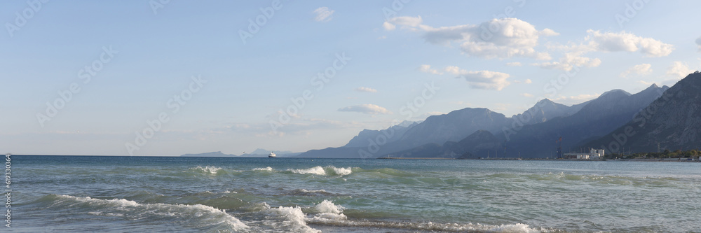 Pebbles beach with blue sky on foggy mountains background