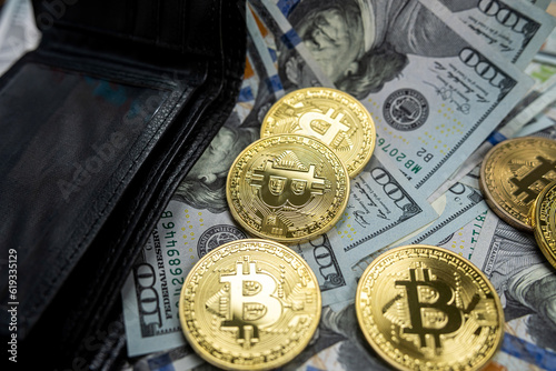 dollar bills in wallet and gold bitcoins on top isolated on black background.