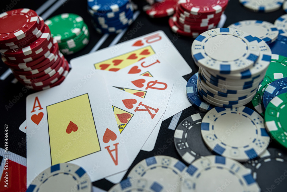 Royal flush combination in five poker card with chips at casino table Royal flush combination in five poker card with chips at casino table