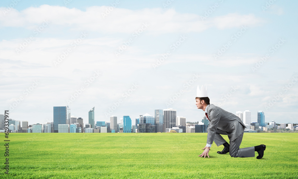 King businessman in elegant suit running on green grass and modern cityscape at background King businessman in elegant suit running on green grass and modern cityscape at background