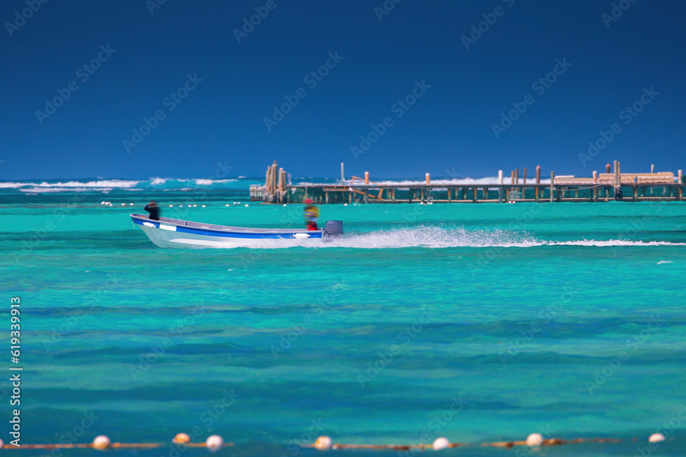 Speed boat surfing over the clear water of caribbean sea, summer tropical vacation