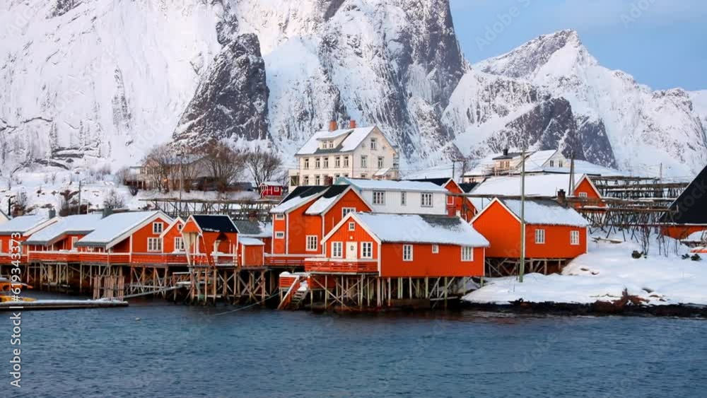 Cold morning view of popular tourist destination - Lofoten Islands. Red houses on the shore of Norwegian sea. Wonderful winter scene of Sakrisoy fishing village. Full HD video (High Definition).