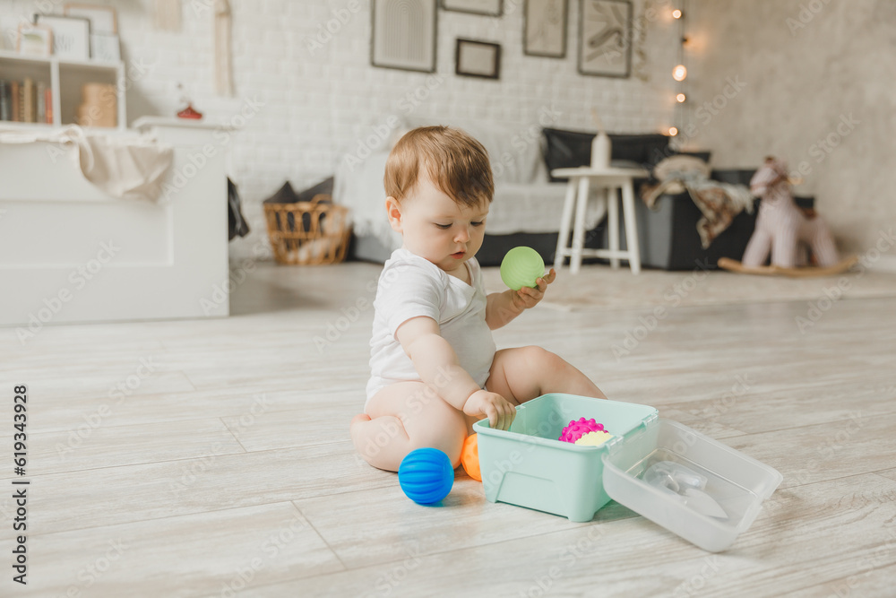 baby 6-9 months old playing with a colorful rainbow toy pyramid sitting in a white sunny bedroom. Toys for small children. Children's interior. A child with an educational toy. baby 6-9 months old playing with a colorful rainbow toy pyramid sitting in a white sunny bedroom. Toys for small children. Children's interior. A child with an educational toy.
