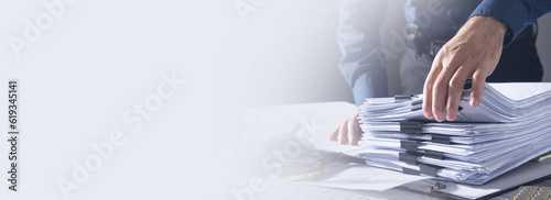 Caucasian businessman holding documents in office.