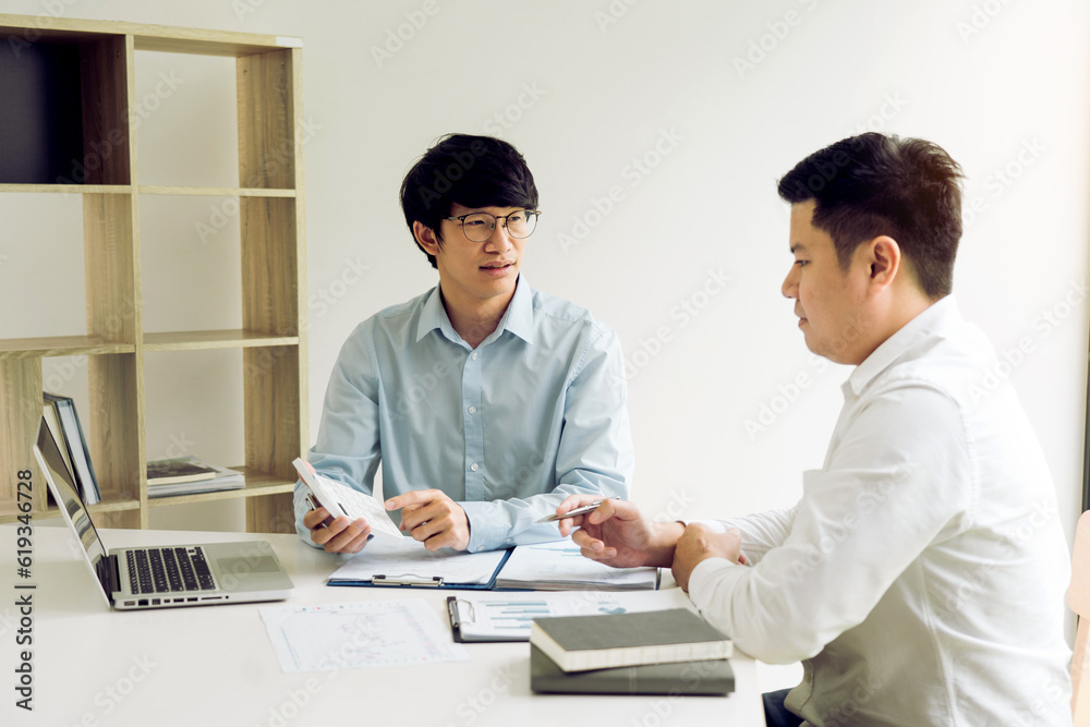 Businessman is pointing to the numbers shown in the budget calculator of the company's finances. Businessman is pointing to the numbers shown in the budget calculator of the company's finances.