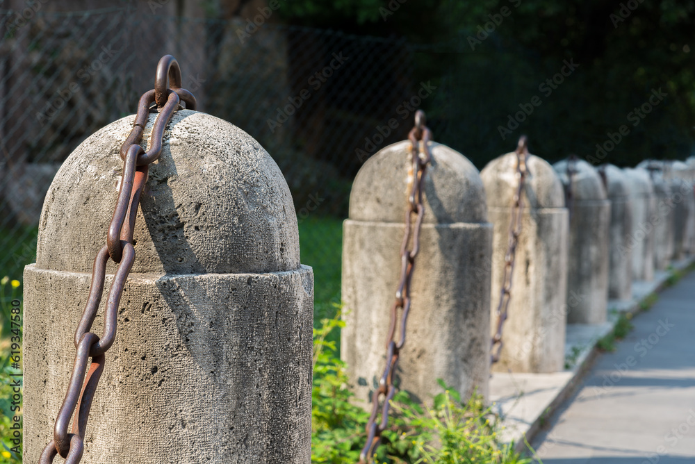 Fence of concrete road column with a chain to block entrance Fence of concrete road column with a chain to block entrance