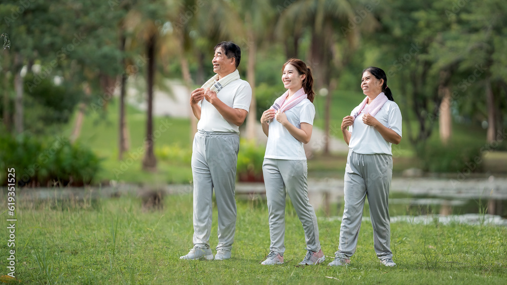 Beautiful Asian woman taking her father and mother to exercise in the park happily, with a smile. Young woman invites parents to exercise, warm family, good health. concept health care life insurance.