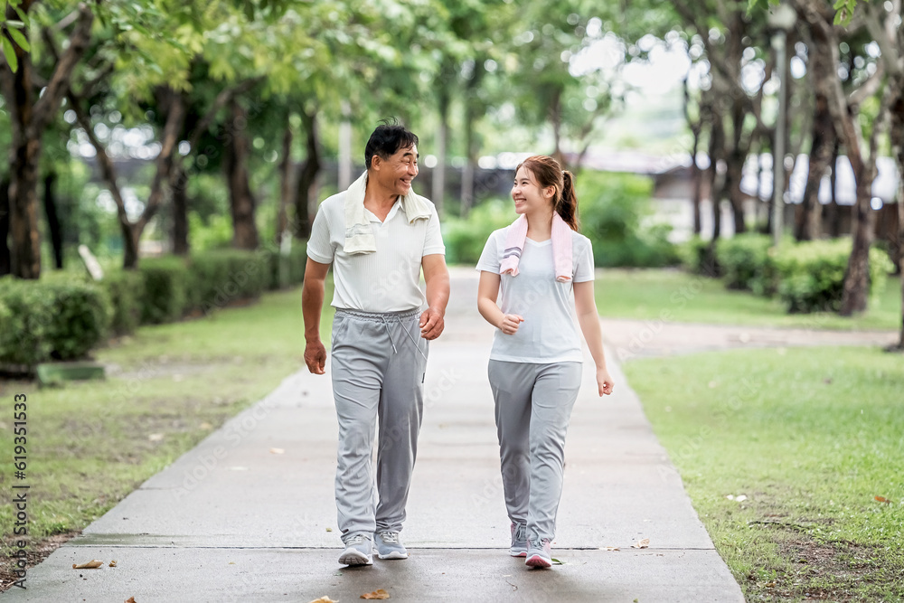 Young beautiful asian woman jogging with her father in park happily, with a smile. Asian woman jogging with her father for health care, park exercise, health care. concept health care life insurance. Young beautiful asian woman jogging with her father in park happily, with a smile. Asian woman jogging with her father for health care, park exercise, health care. concept health care life insurance.