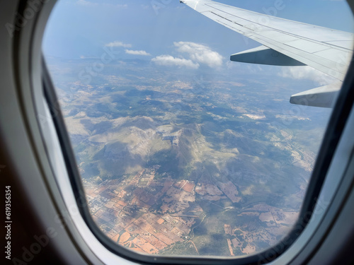 Soar above Mallorca's scenic views in a private jet, capturing nature's beauty through a transparent aircraft wing. Experience the joy of travel and freedom in Spain's paradise.