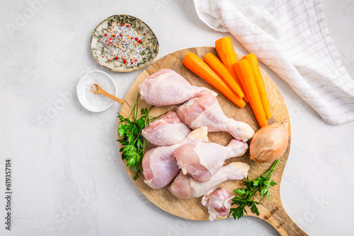 Raw chicken drumsticks with vegetables ans spices prepared for cooking