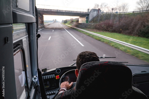 A lone driver commutes on the German autobahn in a coach bus as an overhead view shows the motorway and road below. empty road with no vehicles or obstacles