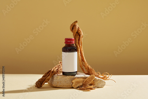 Mockup scene for advertising product with ingredient from herbal. A bottle unlabeled on stone podium, angelica sinensis root and rhizoma atractylodis macrocephalae displayed on brown background. photo