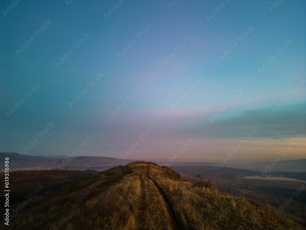 Majestic mountain landscape with colorful sunset sky on the horizon