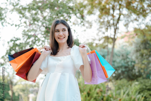 Happy beautiful woman showing credit card and shopping bags with goods, buying with discounts.