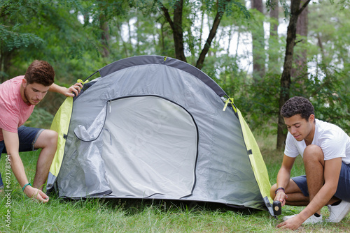 Obraz na plátně two young men erecting tent