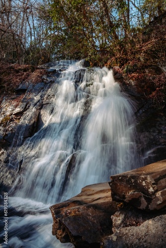 Fototapeta Naklejka Na Ścianę i Meble -  Majestic waterfall cascades down a densely forested ravine.