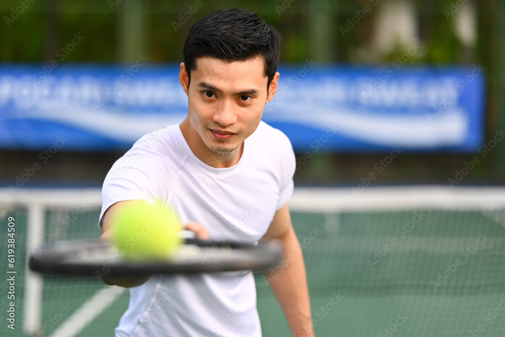 Determined male tennis player holding racket and ball. Sport, training, competition and active life concept