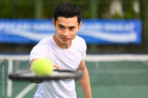 Determined male tennis player holding racket and ball. Sport, training, competition and active life concept