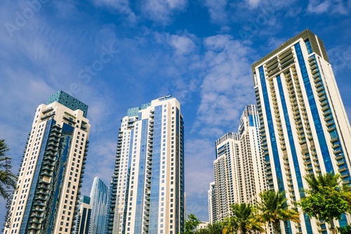 Low angle shot of modern buildings and palm trees in Dubai Creek Harbour, UAE