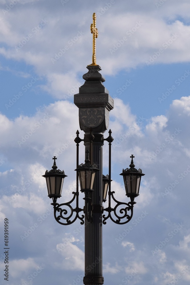 Black and gold lantern-style streetlight against a vibrant cloudy blue sky