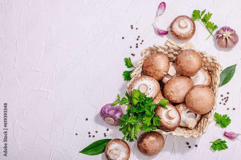 Raw brown royal champignons in the basket. Cooking vegan food concept. Garlic, greens, spices Raw brown royal champignons in the basket. Cooking vegan food concept. Garlic, greens, spices