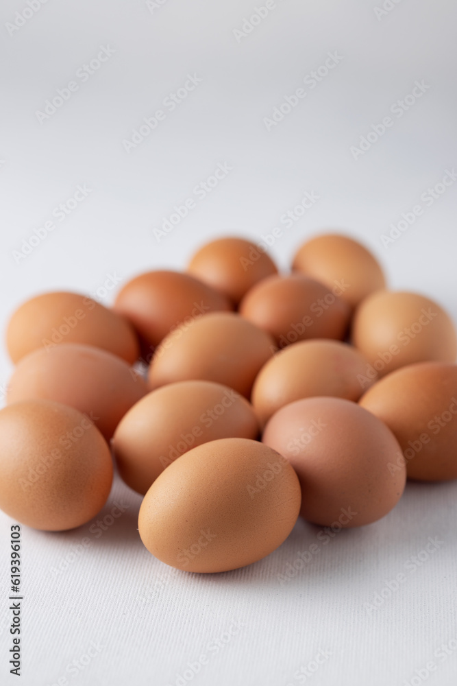 14 eggs with brown shells on a white background. Close-up, copy space