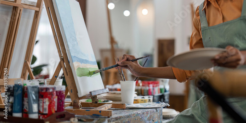 Close up of african american male painter at work painting on canvas in art studio. creation and inspiration at an artists painting studio