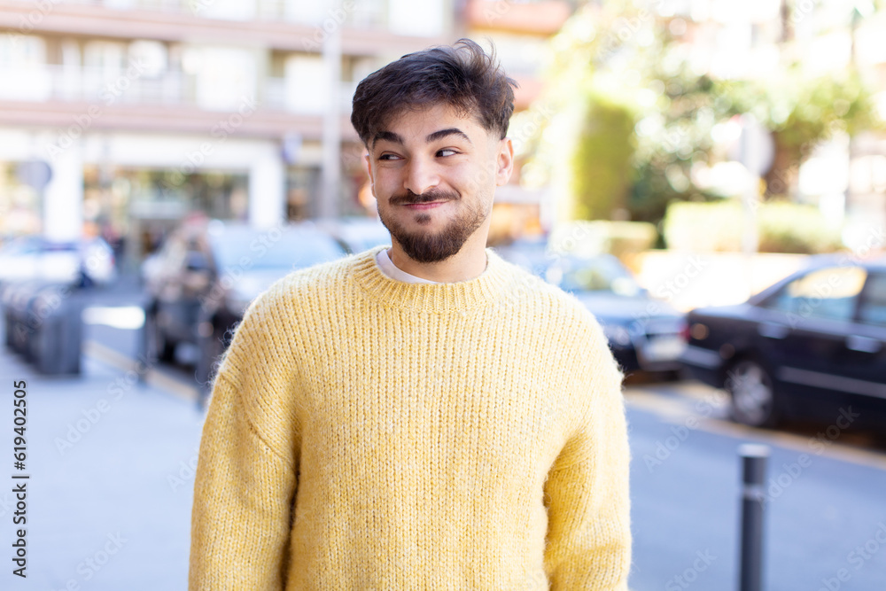young handsome man wondering, thinking happy thoughts and ideas, daydreaming, looking to copy space on side young handsome man wondering, thinking happy thoughts and ideas, daydreaming, looking to copy space on side