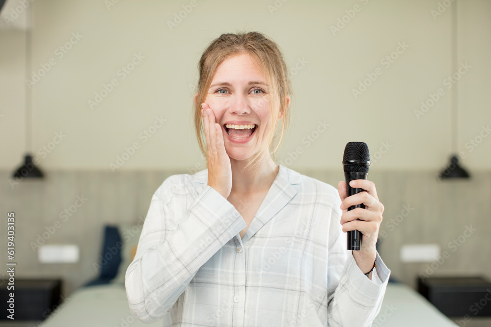 young pretty woman feeling happy and astonished at something unbelievable. microphone concept young pretty woman feeling happy and astonished at something unbelievable. microphone concept