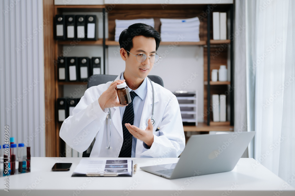 Attractive female doctor talking while explaining medical treatment to patient through a video call with laptop in modern office