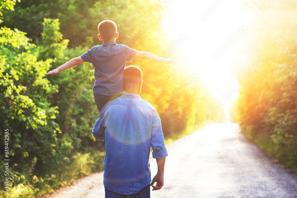 A Happy child on the shoulders of a parent in nature on the way to travel A Happy child on the shoulders of a parent in nature on the way to travel