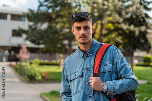 Portrait of a male college student on a university campus outside.