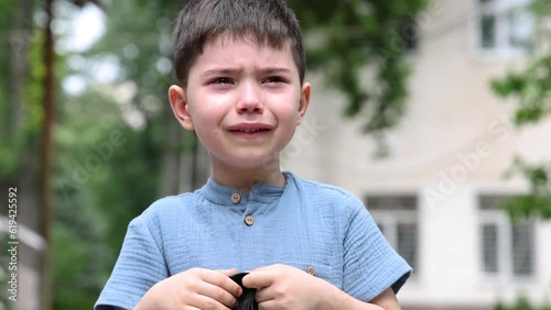 crying preschooler boy going to school with backpack.tears of cute kid child outside the building.4k back to school upset angry dissatisfied feelings