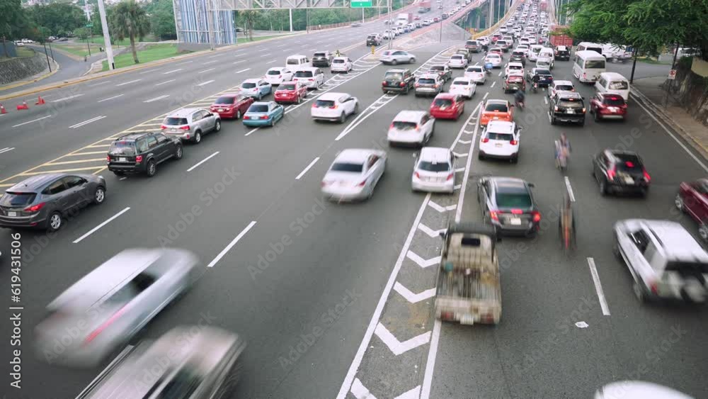 Cinematic time lapse of many cars and trucks driving fast by the road marking asphalt on multi lane speed highway. Blur motion city traffic background