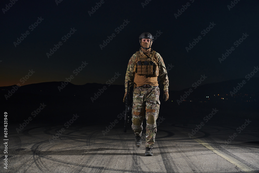 Naklejka premium A professional soldier in full military gear striding through the dark night as he embarks on a perilous military mission