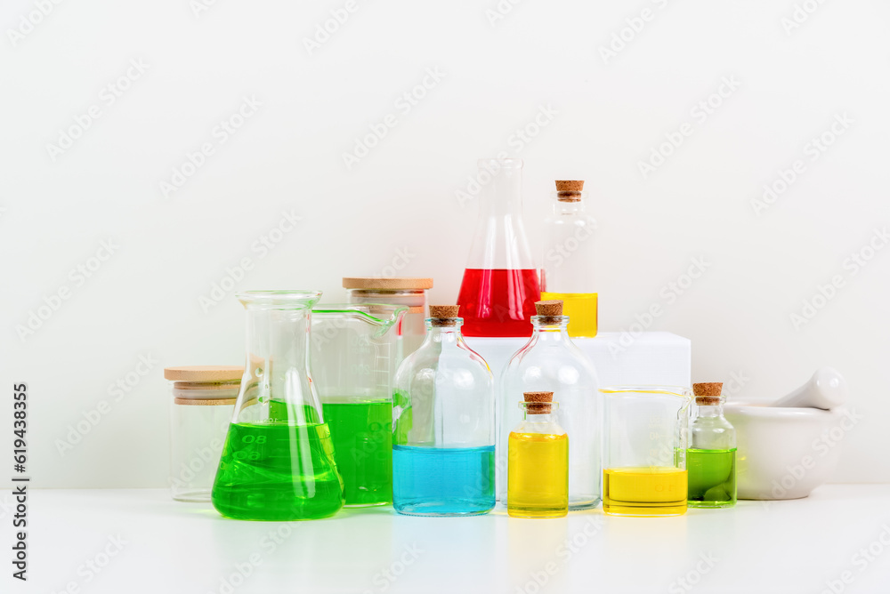 some test tube on the white table with beakers, flasks, and test tubes filled with colorful liquids