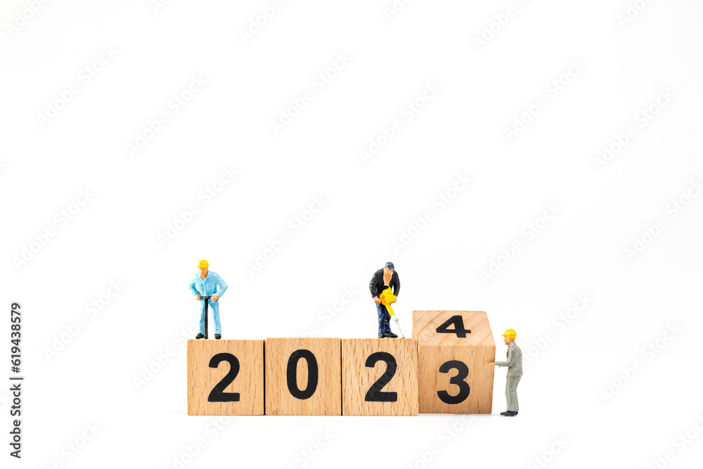 Miniature people , Worker team flips a wooden block with the number 2024