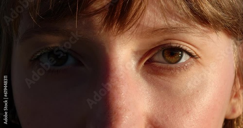 Close-up shot of woman brown eye with light make-up opening and looking at the sun slow motion. The red-haired girl's eyes open. Slow motion. 120FPS. Macro eye photography. The face of a beautiful