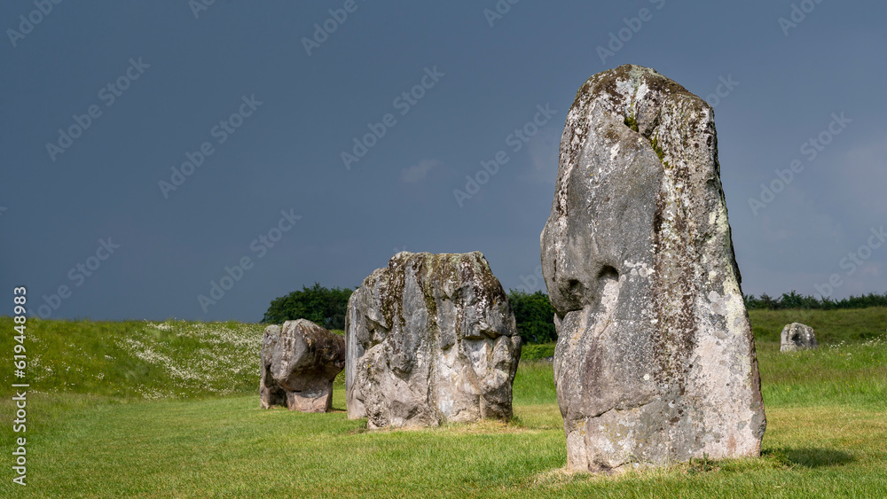 Pierres dressées du site néolithique de Avebury dans le comté de Wiltshire sous un ciel orageux