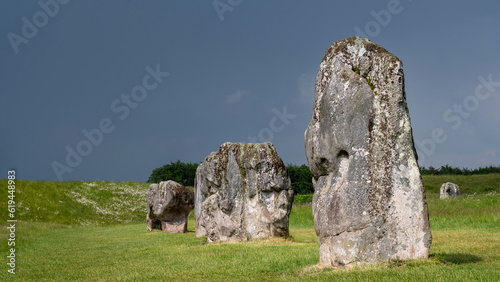 Pierres dressées du site néolithique de Avebury dans le comté de Wiltshire sous un ciel orageux photo