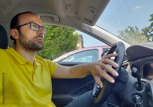 Uomo che guida la sua automobile in una giornata di estate photo