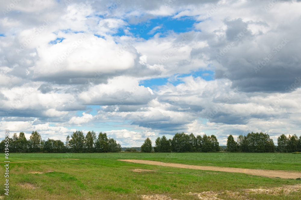 Landscape with a rural road through a field on a summer evening. Landscape with a rural road through a field on a summer evening.