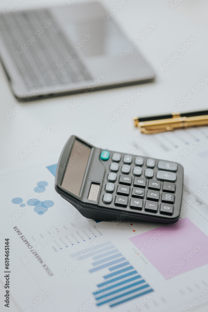 Selective focus office calculator with laptop and accessories on white background financial concept
